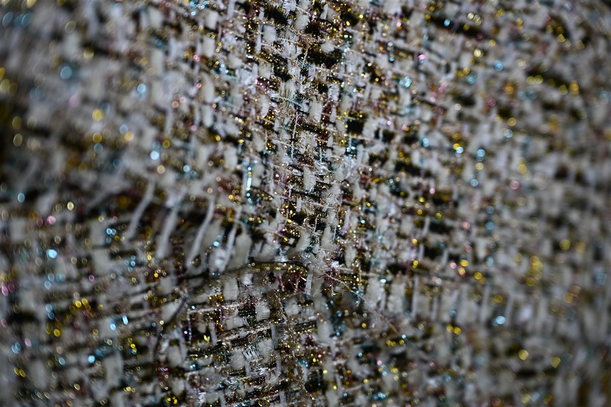 Close-up of premium Chanel-style boucl fabric showcasing intricate weaving and textured yarns, exemplifying Fursone's expertise in luxury tweed fabric manufacturing. This image highlights the high-quality artisan aesthetic offered through our in-stock and custom MOQ boucl fabric solutions from Wenzhou textile specialists since 1995.