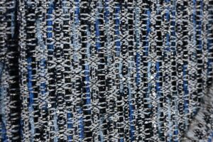 Close-up image of premium Chanel-style bouclé fabric showcasing textured yarns and intricate knit patterns, representing Fursone's heritage cable knits and luxury fabric manufacturing expertise from Wenzhou since 1995.