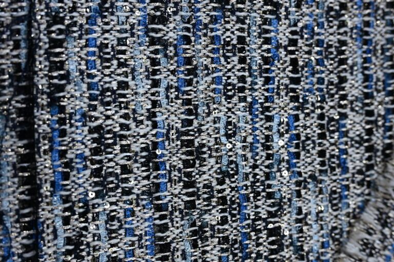 Close-up image of premium Chanel-style bouclé fabric showcasing textured yarns and intricate knit patterns, representing Fursone's heritage cable knits and luxury fabric manufacturing expertise from Wenzhou since 1995.