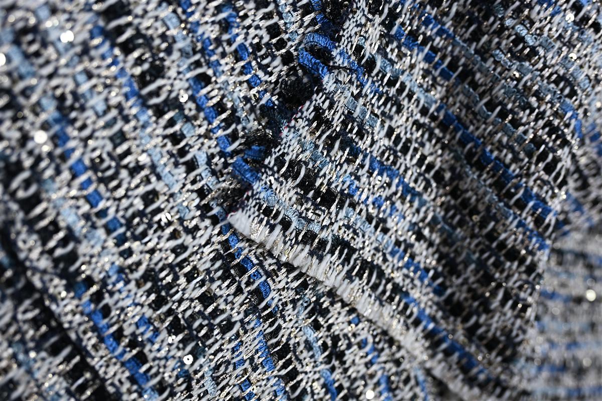 Detailed macro image of premium Chanel-style boucl fabric showcasing intricate texture and shimmer, representing Fursone's expertise in sourcing tweed fabric from Wenzhou. This visual highlights our ready stock and custom bespoke fabric solutions optimized for high-end luxury collections.