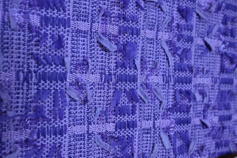 A detailed close-up of premium Chanel-style bouclé fabric showcasing intricate textured loops and woven patterns, representing Fursone's expertise in luxury fabric manufacturing. This image highlights the artisan aesthetic of bouclé fabric available in ready stock and custom bespoke options from China textile specialists.
