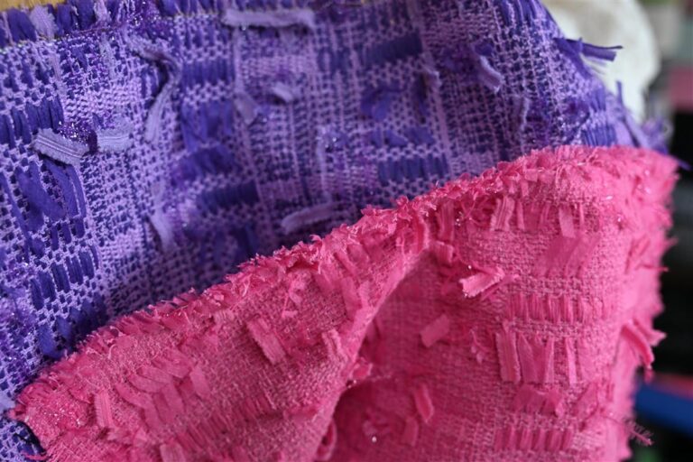 Close-up of vibrant purple and pink Chanel-style bouclé fabric showcasing textured artisan weaves. This image highlights Fursone’s premium tweed fabric ready stock, embodying our core expertise in rapid sampling and affordable luxury fabric manufacturing for womenswear brands.