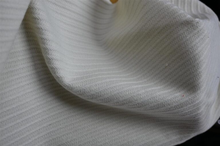 Close-up image of premium heritage cable knit fabric displaying intricate texture and craftsmanship, representing Fursone's expertise in luxury fabric manufacturing. This fabric exemplifies our commitment to affordable luxury with European mill quality and 7-day rapid sampling for custom bespoke fabric development.