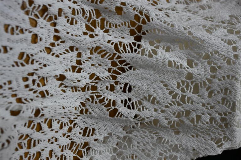 Detailed close-up of intricately knitted white bouclé fabric showcasing premium texture and artisan craftsmanship, representing Fursone's Chanel-Style Bouclé Fabric with 100M meters ready stock for global high-end fashion brands sourced from Wenzhou Textile Expertise.