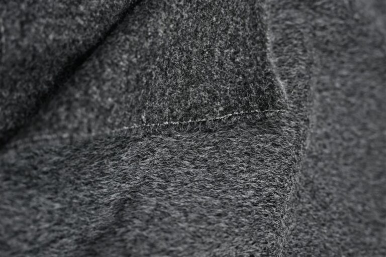 Detailed macro image of high-quality bouclé fabric showcasing its textured yarns, representing Fursone's premium Chanel-style bouclé fabric used in luxury fabric manufacturing. Ideal for global fashion brands seeking custom bespoke fabric development with rapid sampling and ready stock solutions.